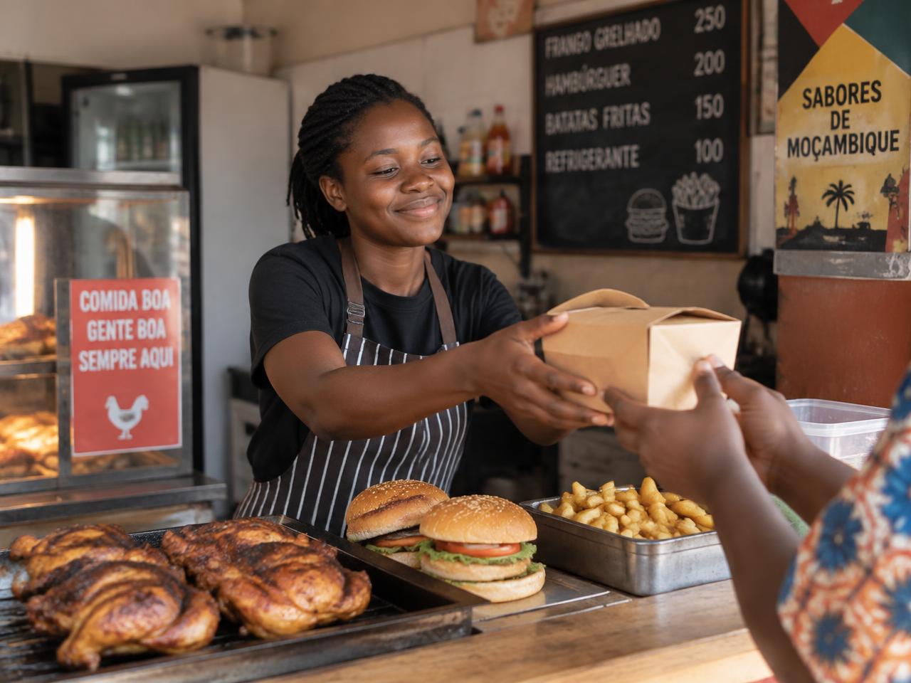 Dona de um takeaway a entregar uma encomenda ao cliente